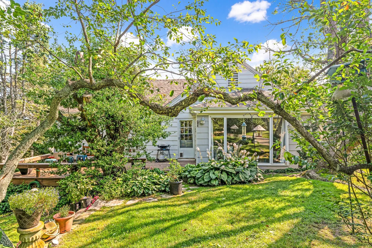 Storybook shingle-style exterior of the 6 Chapel Place estate, showing weathered cedar shingles nestled within the private, tree-filled landscape of Watch Hill. (Source: realtor.com)