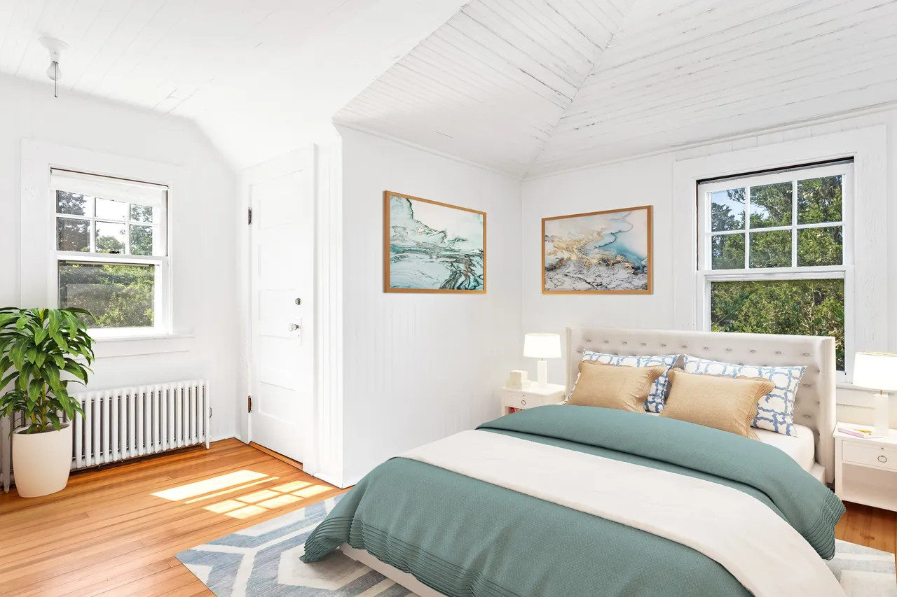 Corner bedroom in the 1920s-built mansion, featuring double-aspect windows that capture the soft coastal morning light of Watch Hill. (Source: realtor.com)