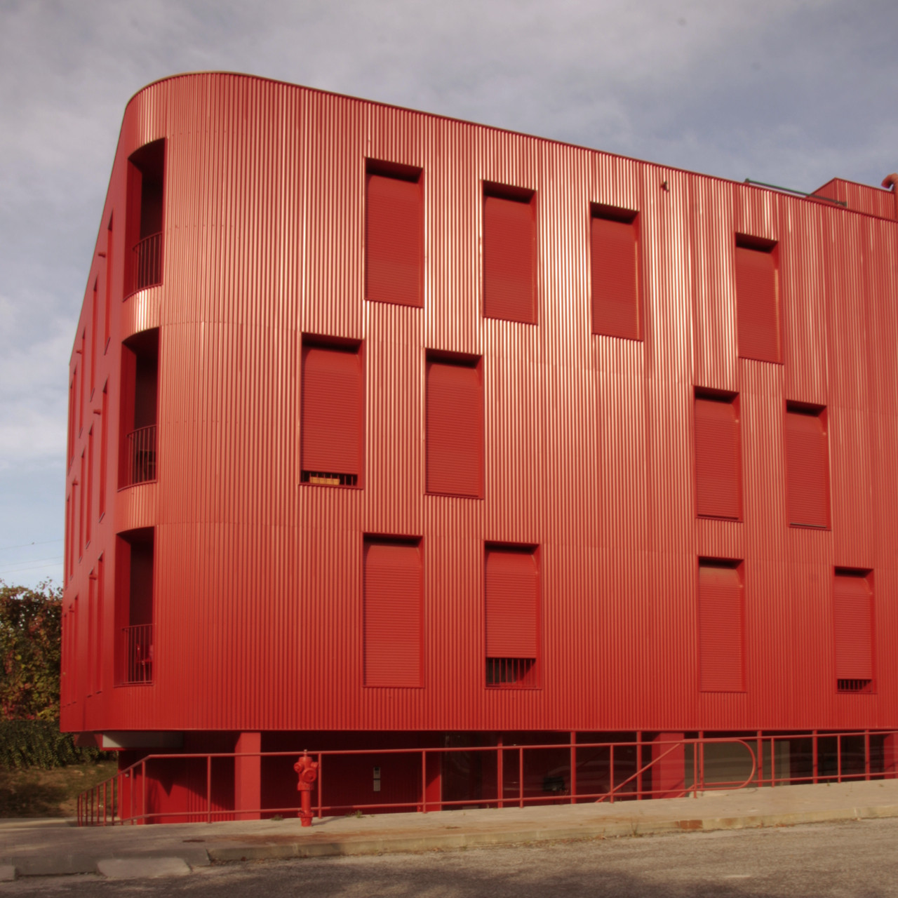 A series of perforated and corrugated openings on the red metal façade (Photo: Santo Eduardo Di Miceli)