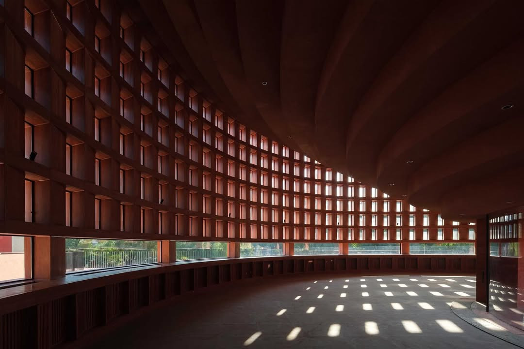 Diamond-shaped red travertine masonry that modulates light (Photo: Instagram / @neriandhu)