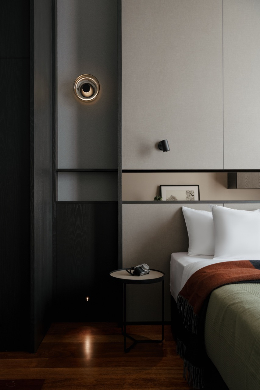Concealed LED lighting illuminates the space between taupe panels and dark ebony-stained ash veneer