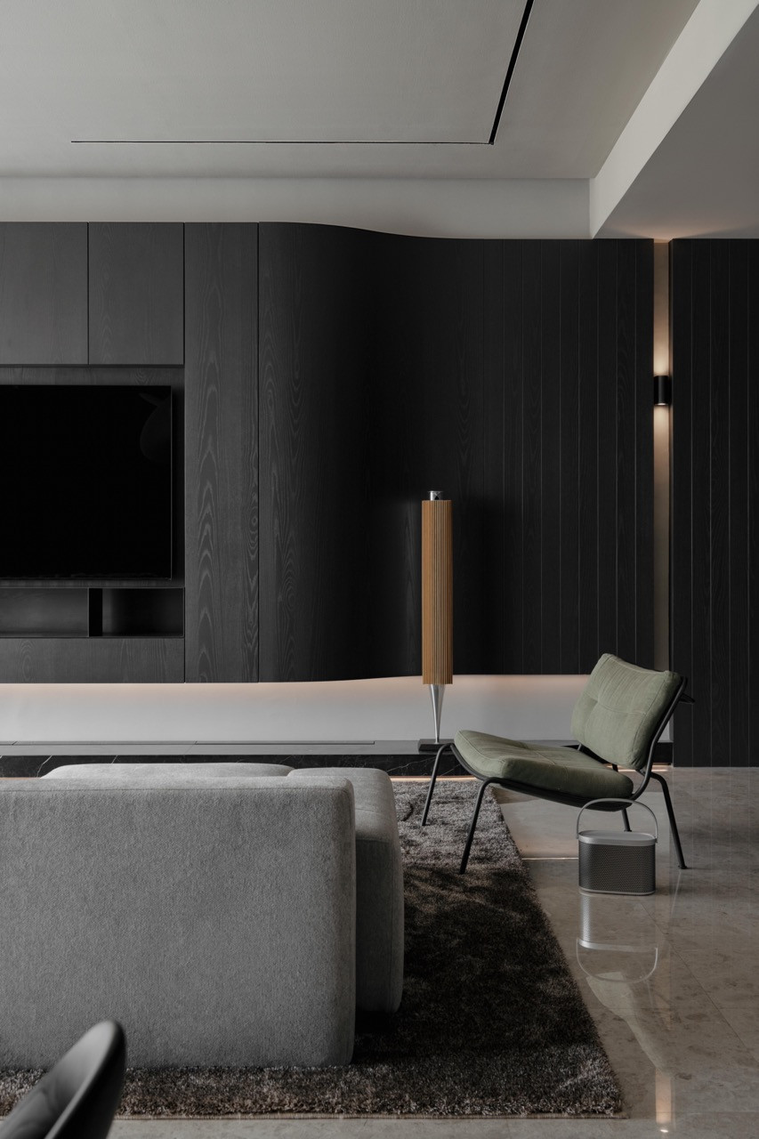 The living room features dark timber panels with concealed lighting and a Beolab 18 sound column