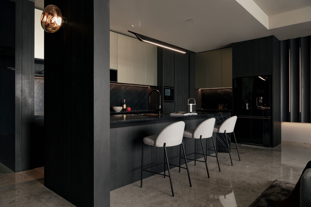 Dark timber columns frame the Black Marquina marble island with concealed LED lighting beneath