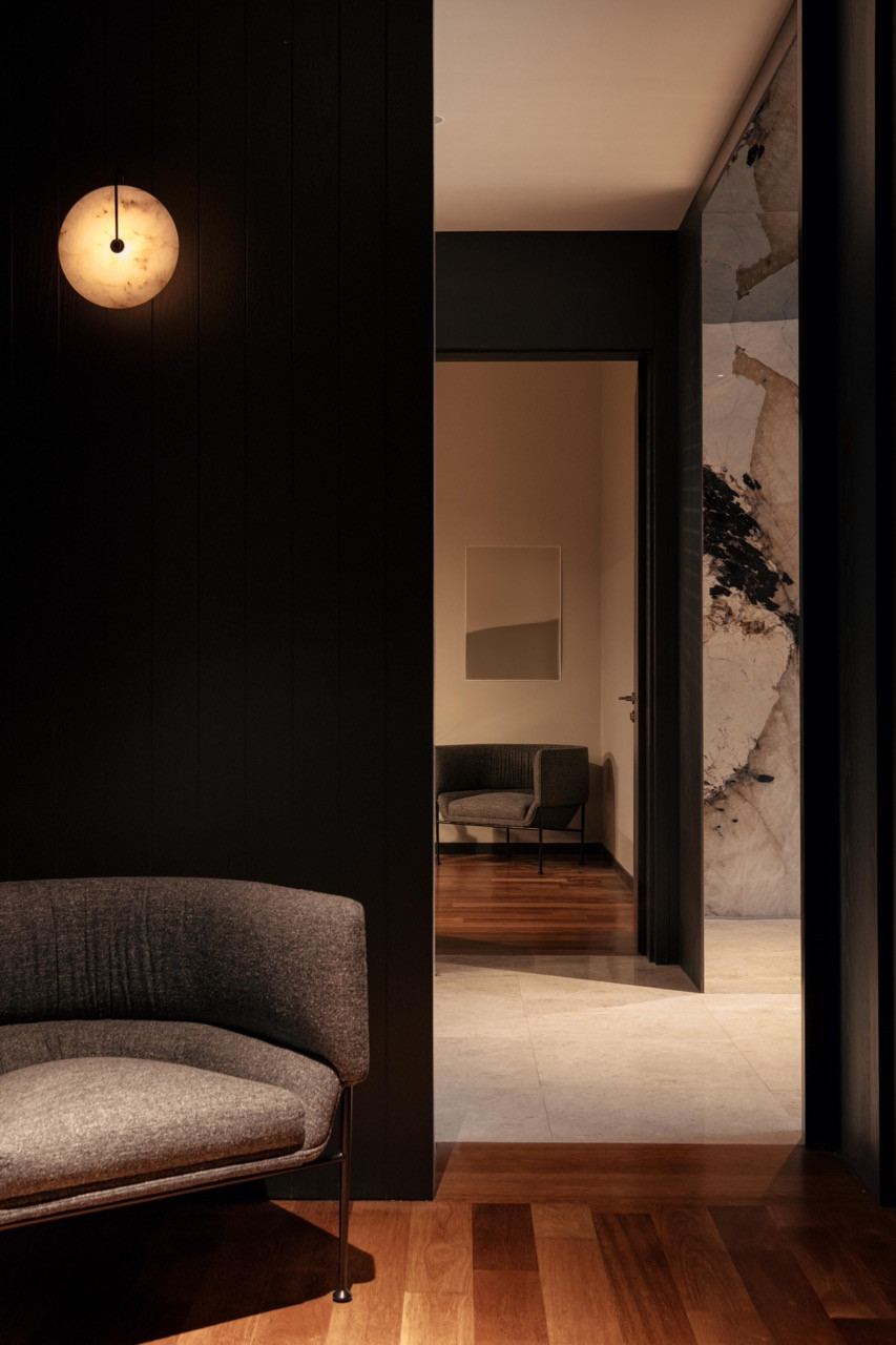 The vestibule features backlit Patagonia quartzite with a Collar lounge chair by Wendelbo visible beyond