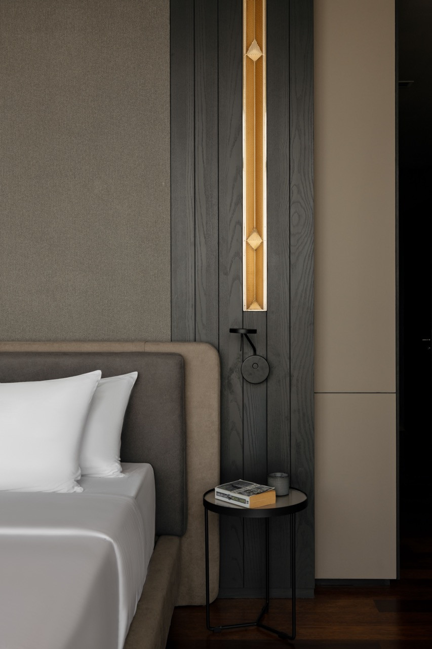 Detail of the bedroom’s custom lighting with concealed LED strips behind perforated metal sheets