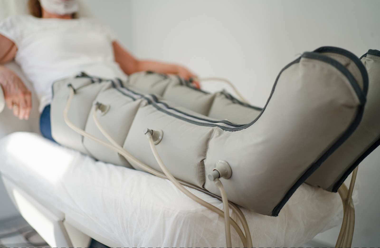 A woman with intermittent pneumatic compression devices lies down at a spa clinic (Photo: Getty Images)