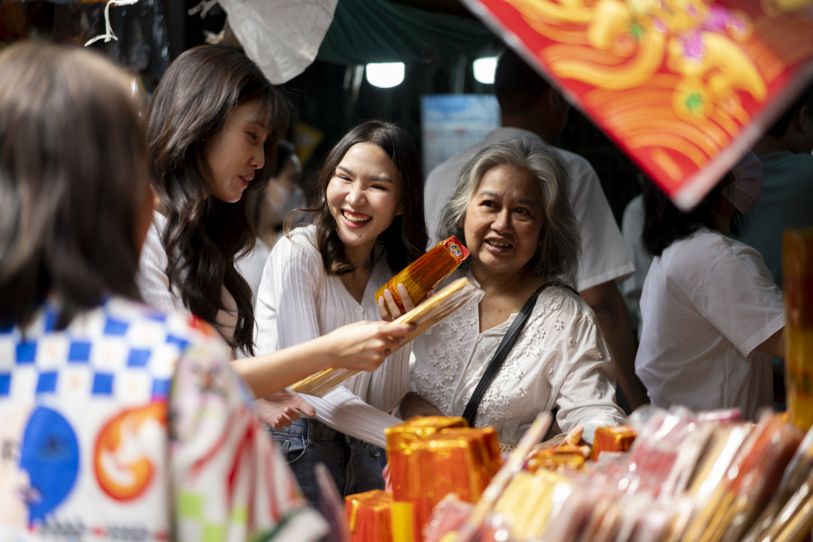 Selective focus, Mother and two daughter shopping before Chinese New Year, choose and buying incense in market, They are smile with happiness together (ภาพ: pixs4u / Getty Images)
