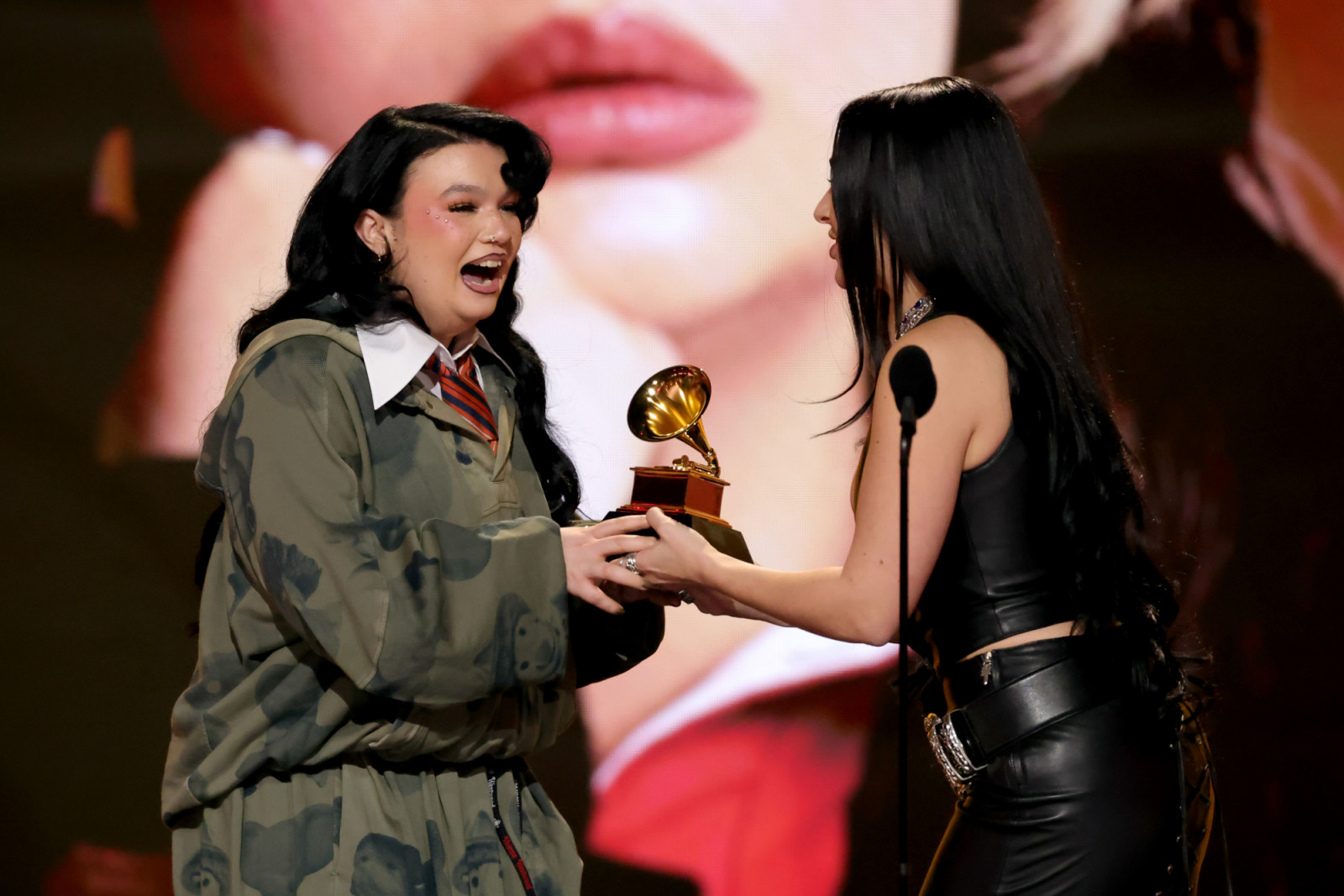 LOS ANGELES, CALIFORNIA - FEBRUARY 01: (L-R) Lola Young accepts the award for Best Pop Solo Performance for "Messy" from Charli xcx onstage during the 68th GRAMMY Awards at Crypto.com Arena on February 01, 2026 in Los Angeles, California.  (Photo by Kevin Winter/Getty Images for The Recording Academy)