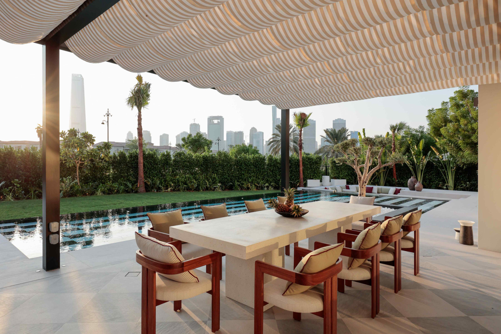 The outdoor dining area with glimpses of the city skyline beyond manicured hedges
