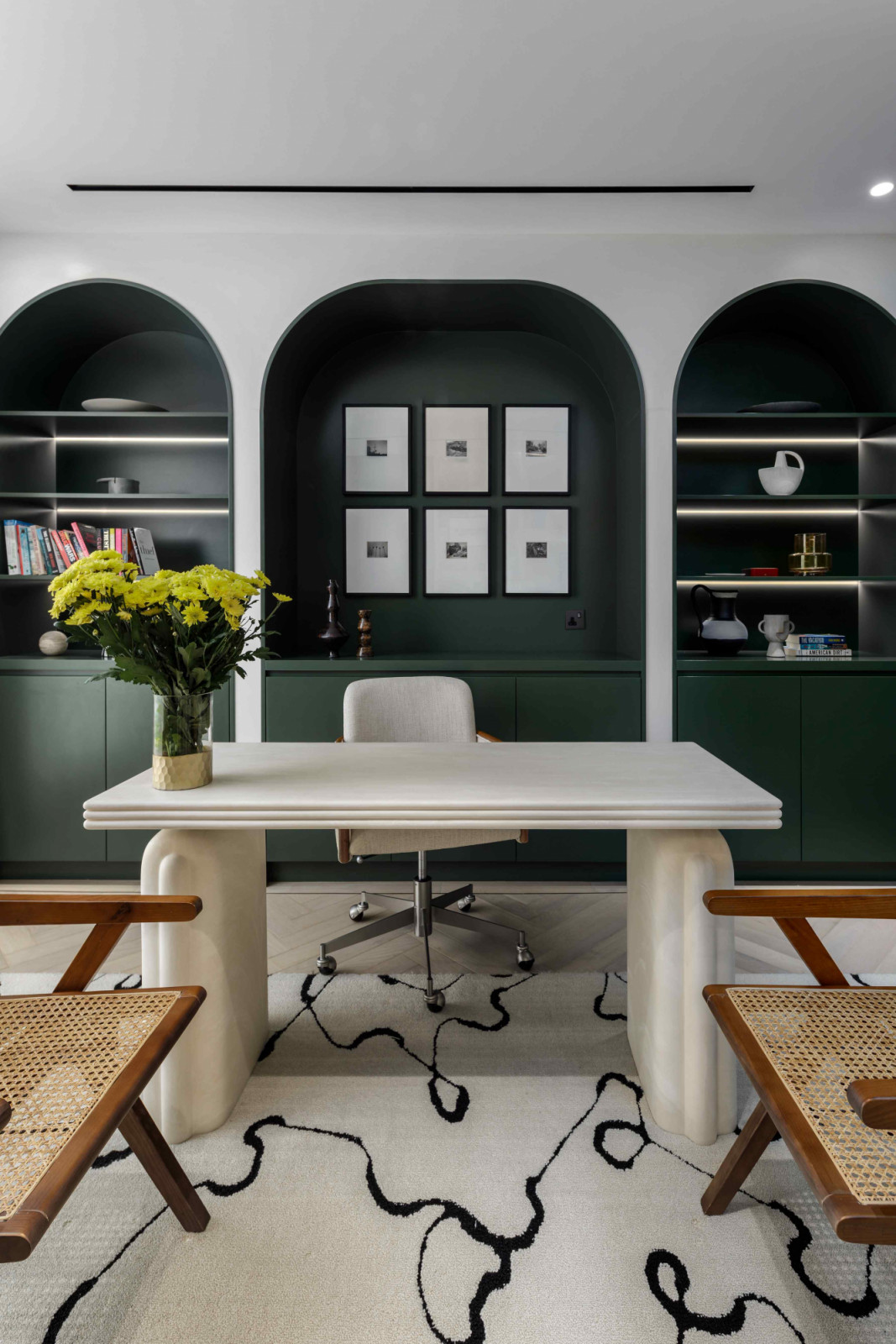 A CB2 stone table and framed Polaroids by Cyrus Mahboubian