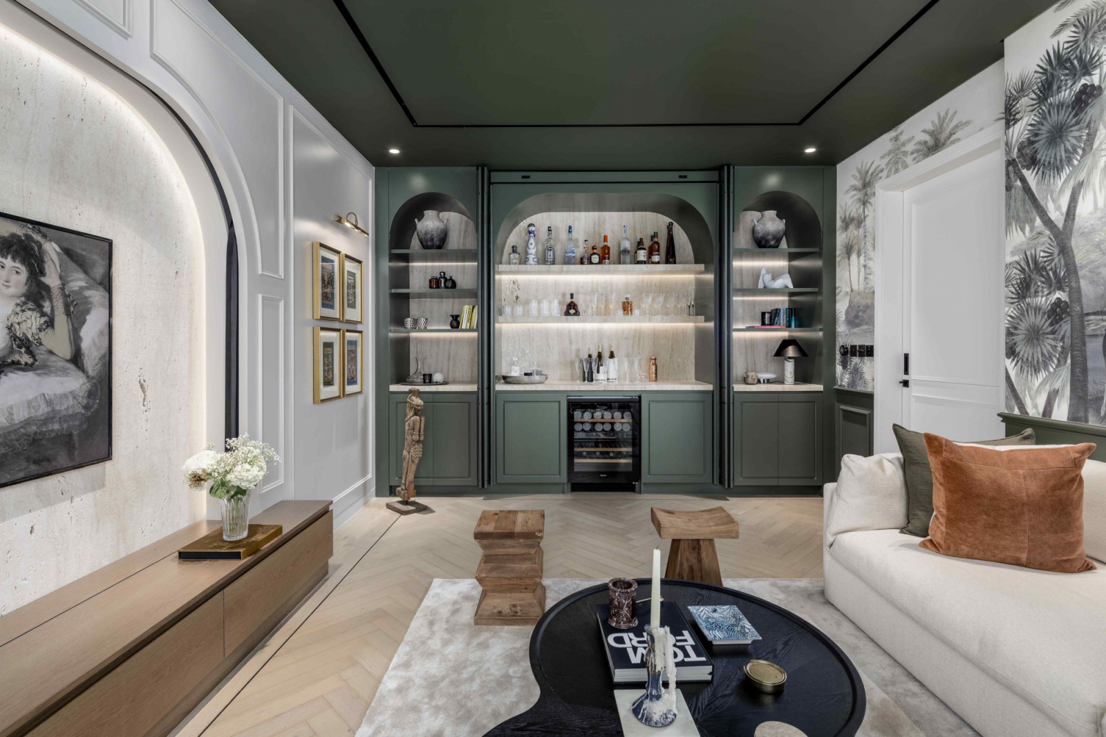 A feature wall clad in tropical-inspired Ananbo wallpaper in the TV room and cabinetry and ceilings painted in deep green tones