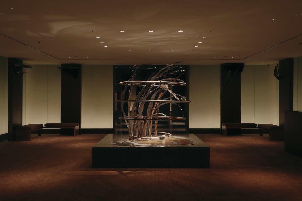 A sculptural installation anchors the hotel’s minimalist lobby, where natural materials and contemporary art define the space