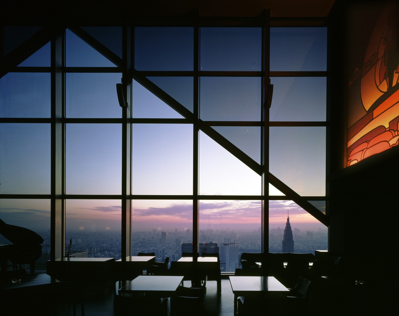 Tokyo's skyline from the New York Bar on the 52nd floor at dusk, with the Tokyo Metropolitan Government Building visible in the distance
