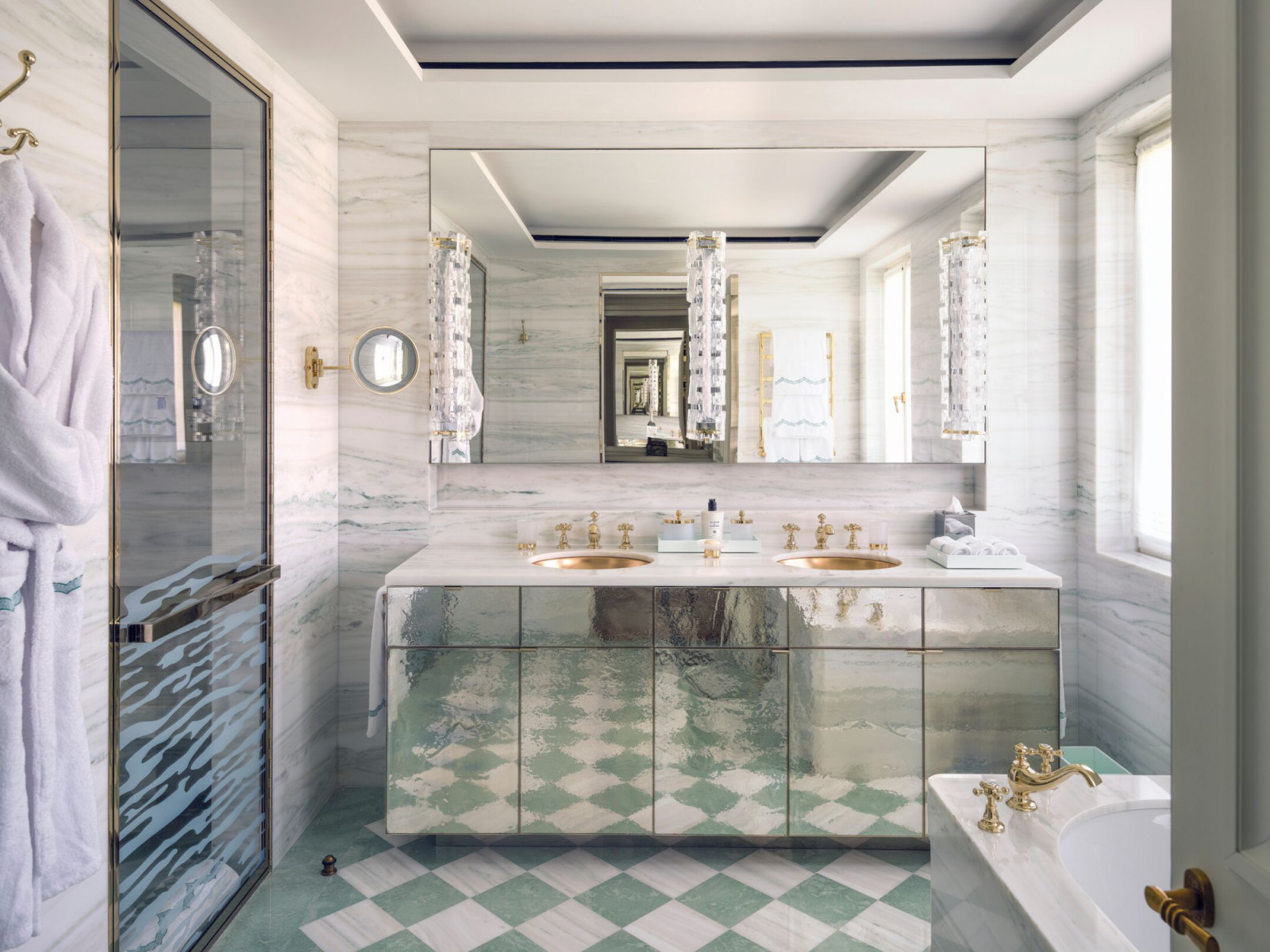 Antiqued mirror vanities and striato marble define the contemporary luxury bathrooms throughout this Venice film hotel
