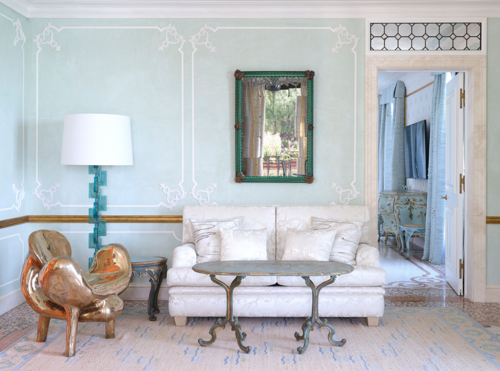 Rococo plasterwork and celadon tones reference mid-century Dolce Vita glamour, one of three design eras Marino incorporated throughout the film hotel