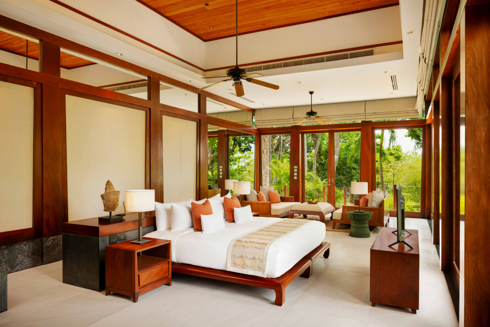 Premier Ocean Bedroom, where generous proportions, warm timber finishes and full-height glazing open the space to lush greenery