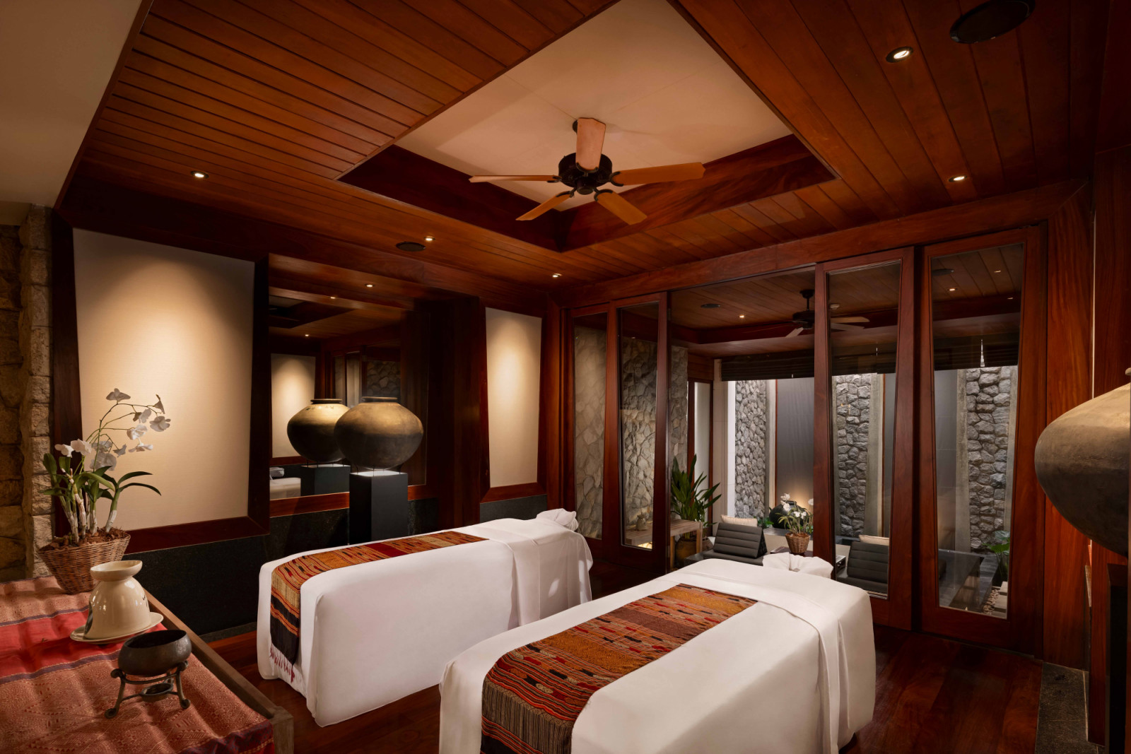 The moody spa is defined by natural dark stone finishes and warm, red-toned timber