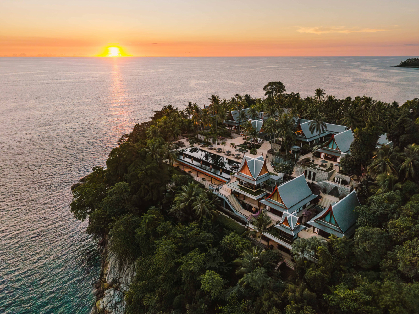 An aerial view at sunset shows Chandara oriented towards the sea horizon, where the estate takes in views of the setting sun over the Andaman Sea