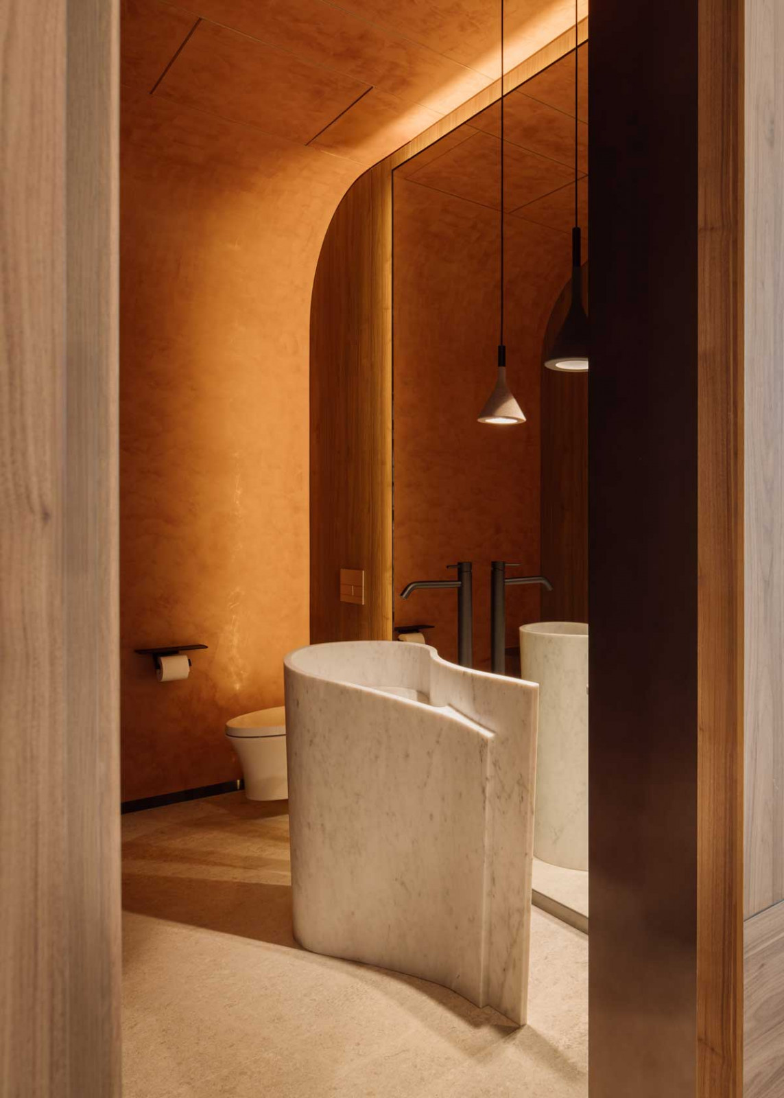 The main powder room features a striking freestanding sink sculpted from a single block of Calacatta marble