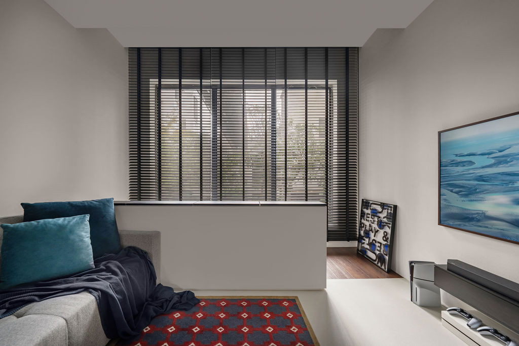 The first-floor study area functions as both a living space and a workspace, with black louvres filtering natural light