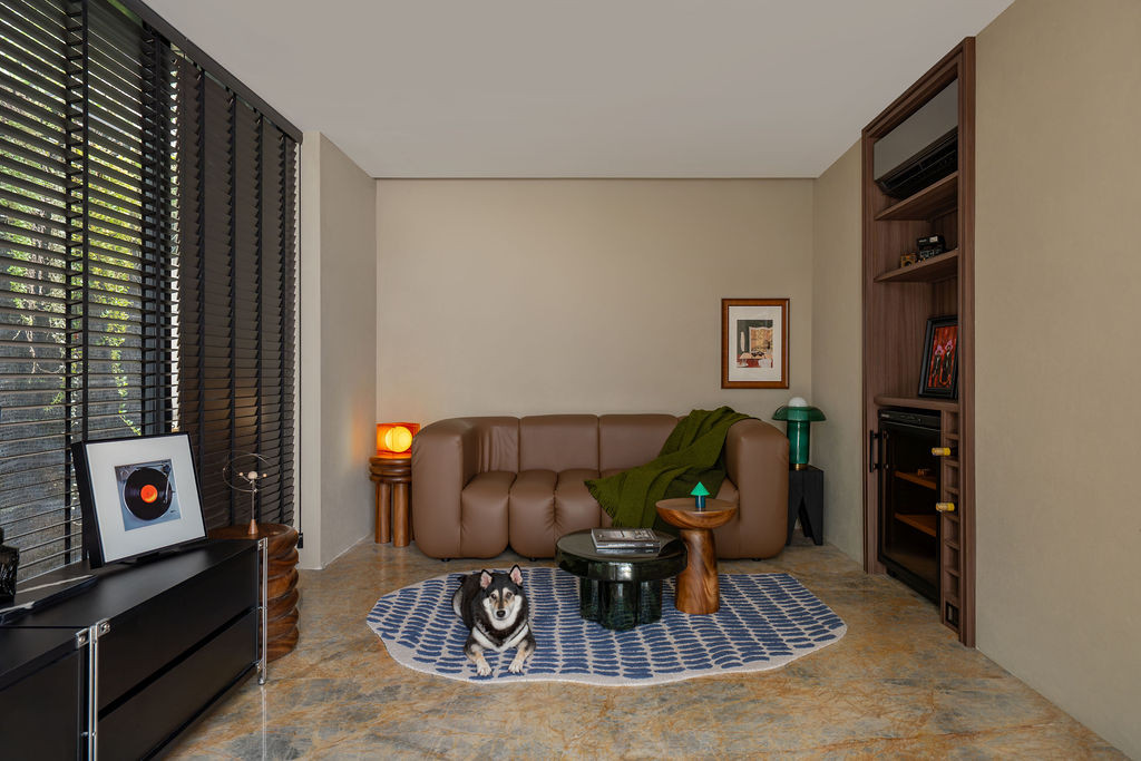 Giallo Venato marble flooring anchors the living room, where custom leather seating sits beneath textured wall coating