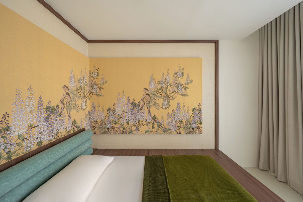 Botanical wallpaper wraps the master bedroom's sunken platform, creating an intimate enclosure framed by walnut trim