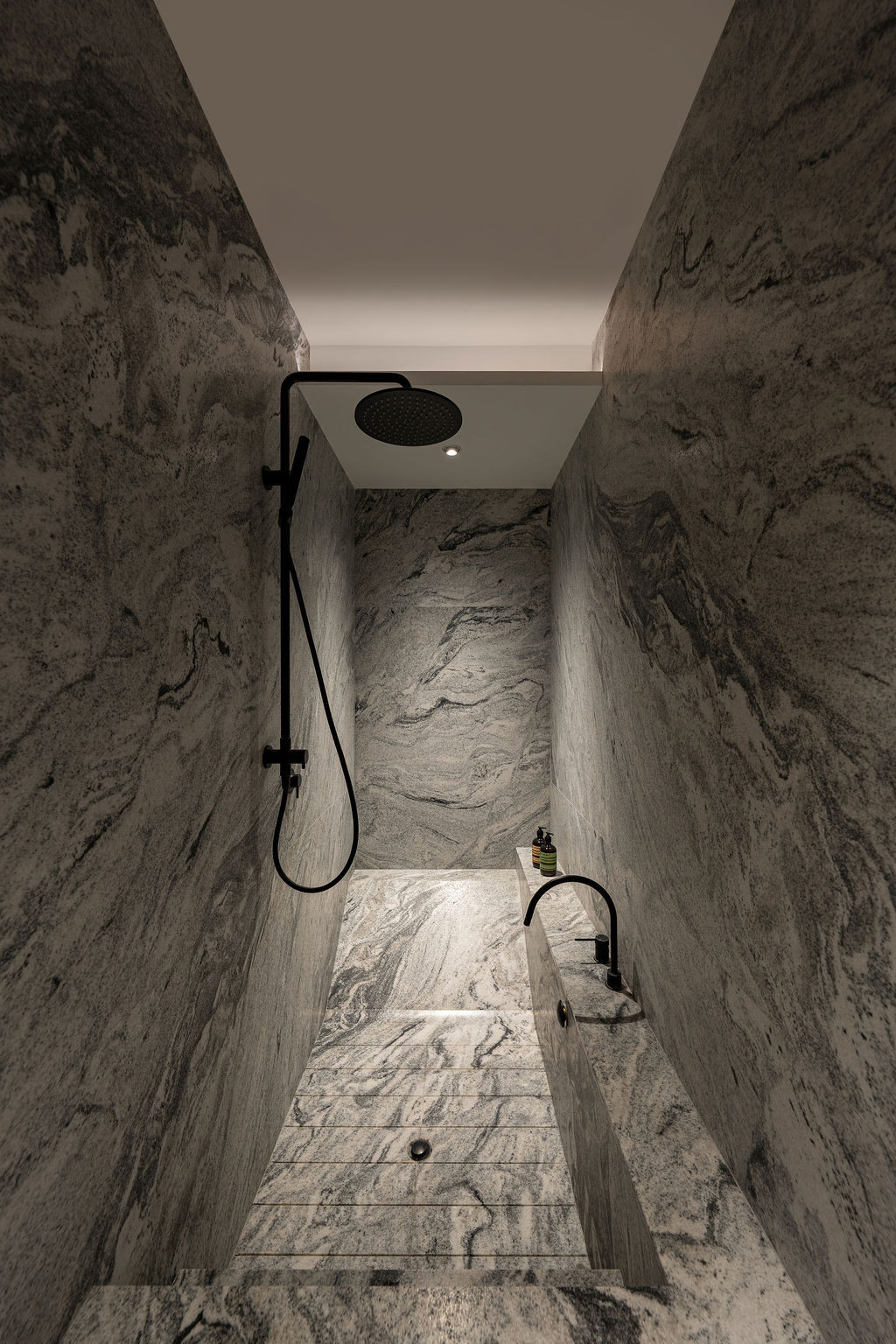 The master bathroom is fully clad in honed Viscount White granite and incorporates a custom sunken bathtub and shower area
