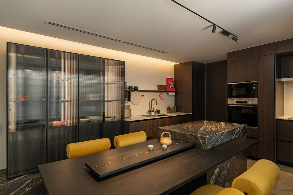 The black quartzite island is subtly translucent when backlit, creating a focal point in the dining area