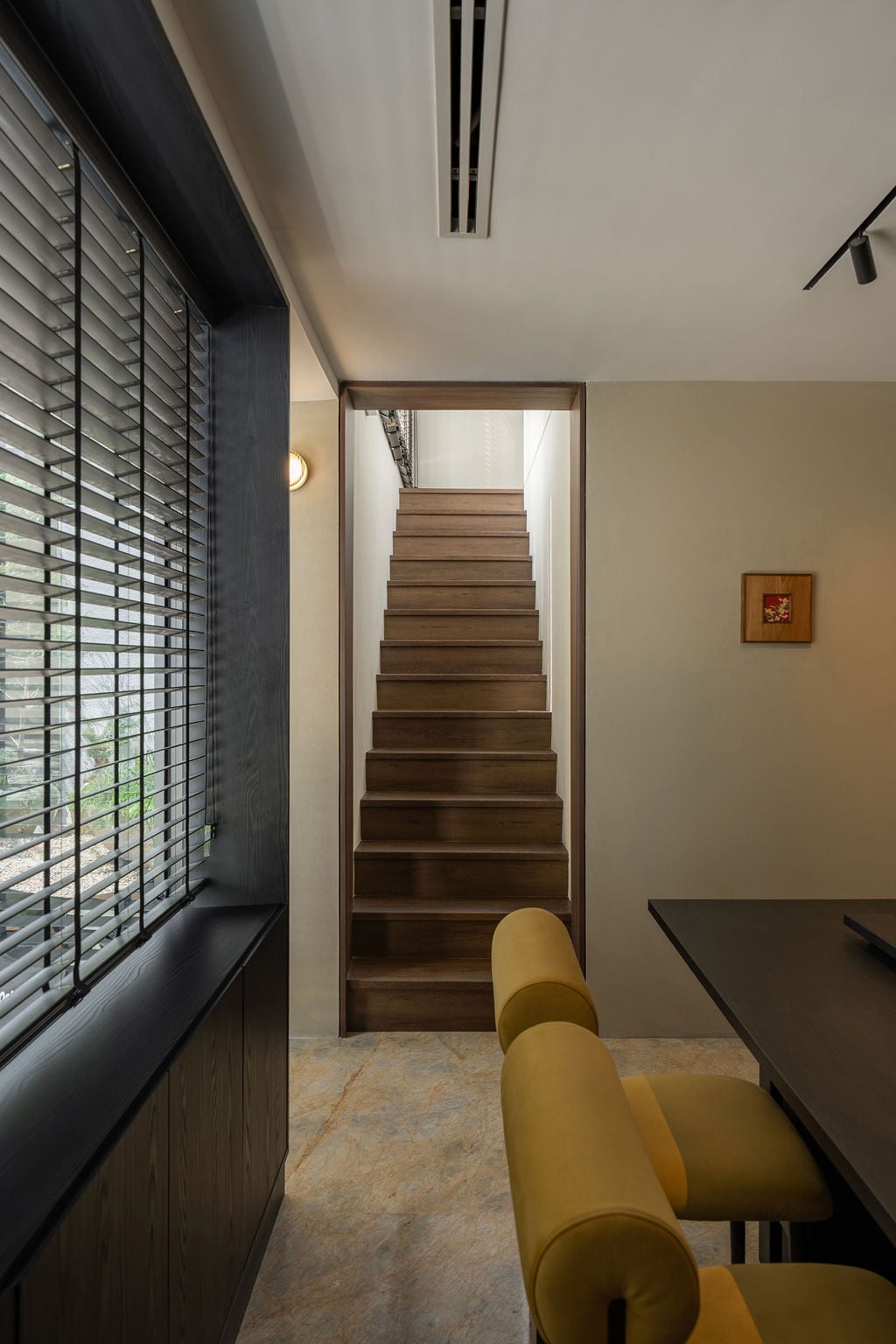 A walnut-clad staircase adjacent to the dining area connects the ground floor to the first floor’s private quarters