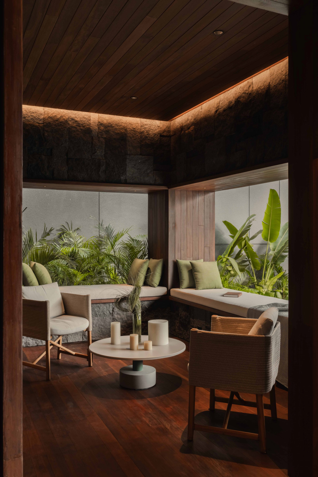 Subtle cove lighting enhances the atmosphere of this sitting area, with views extending towards the greenery outside