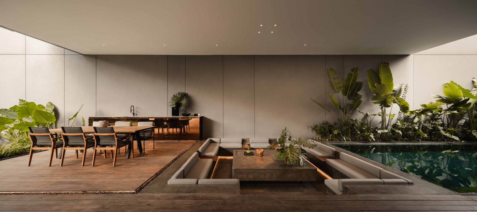 The outdoor dining terrace and sunken conversation pit frame the pool, forming a communal outdoor living zone