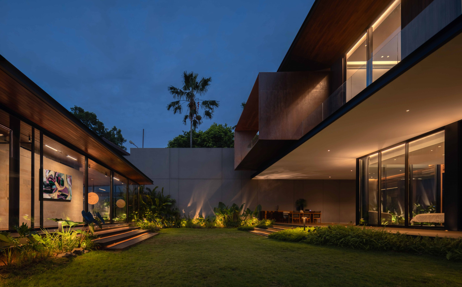 A landscaped green yard separates the main residence from the gallery and gym at the rear of the site