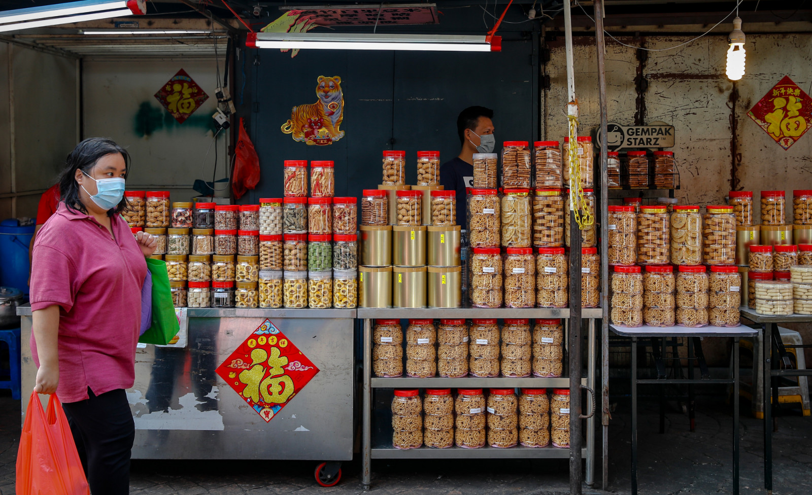 KUALA LUMPUR, MALAYSIA - 2022/01/30: A woman walks past a store selling Chinese New Year cookies in the Chinatown district ahead of the Lunar New Year celebrations.
Lunar New Year falls on February 1, and welcome the year of Tiger will be celebrated Chinese around the world. (Photo by Wong Fok Loy/SOPA Images/LightRocket via Getty Images)