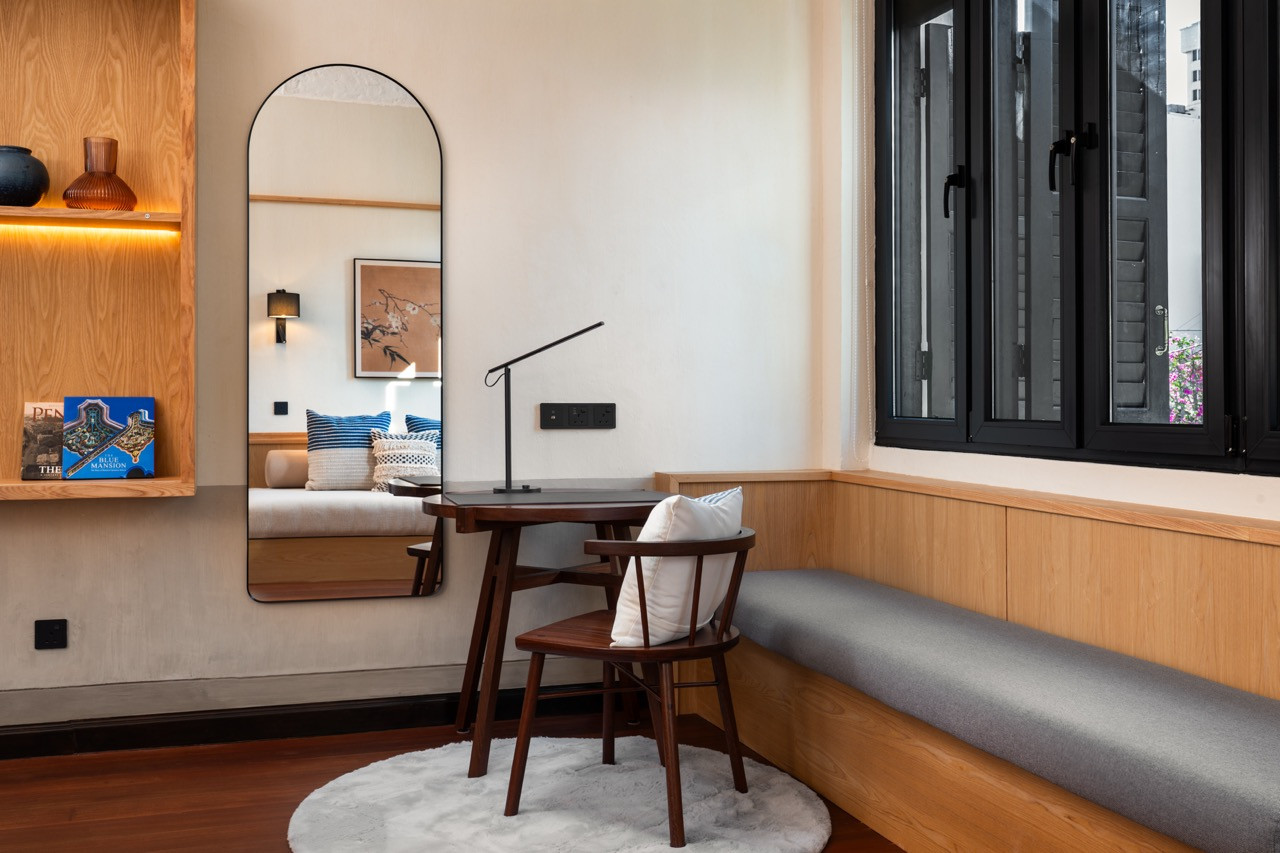 Writing desk and lounge area in a Signature Suite, with salvaged timber flooring and built-in storage, also custom furniture by Penang makers, including Dad’s Wood