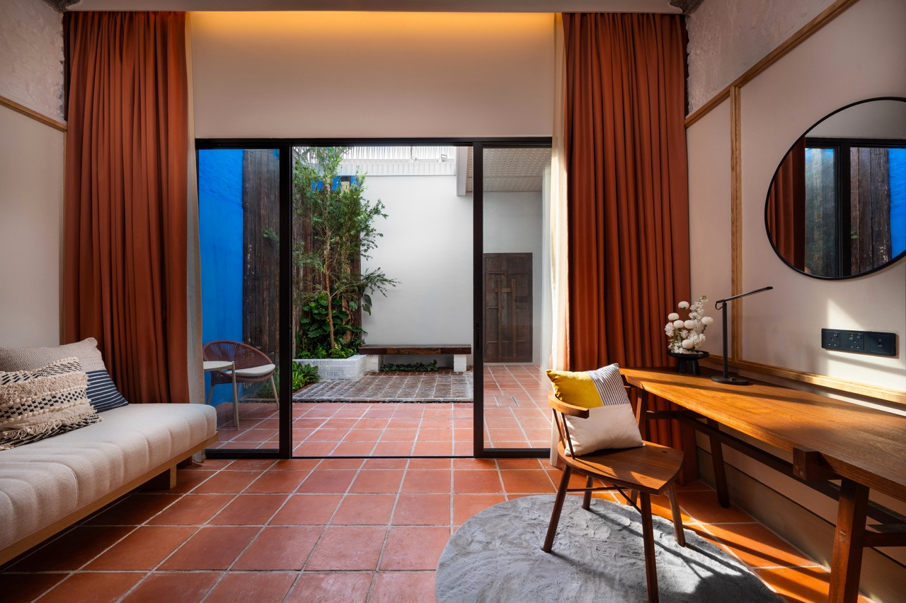The Garden Suite interiors open to the private walled courtyard with Terracotta tiles that continue from interior to exterior, blurring boundaries between conditioned and open-air spaces