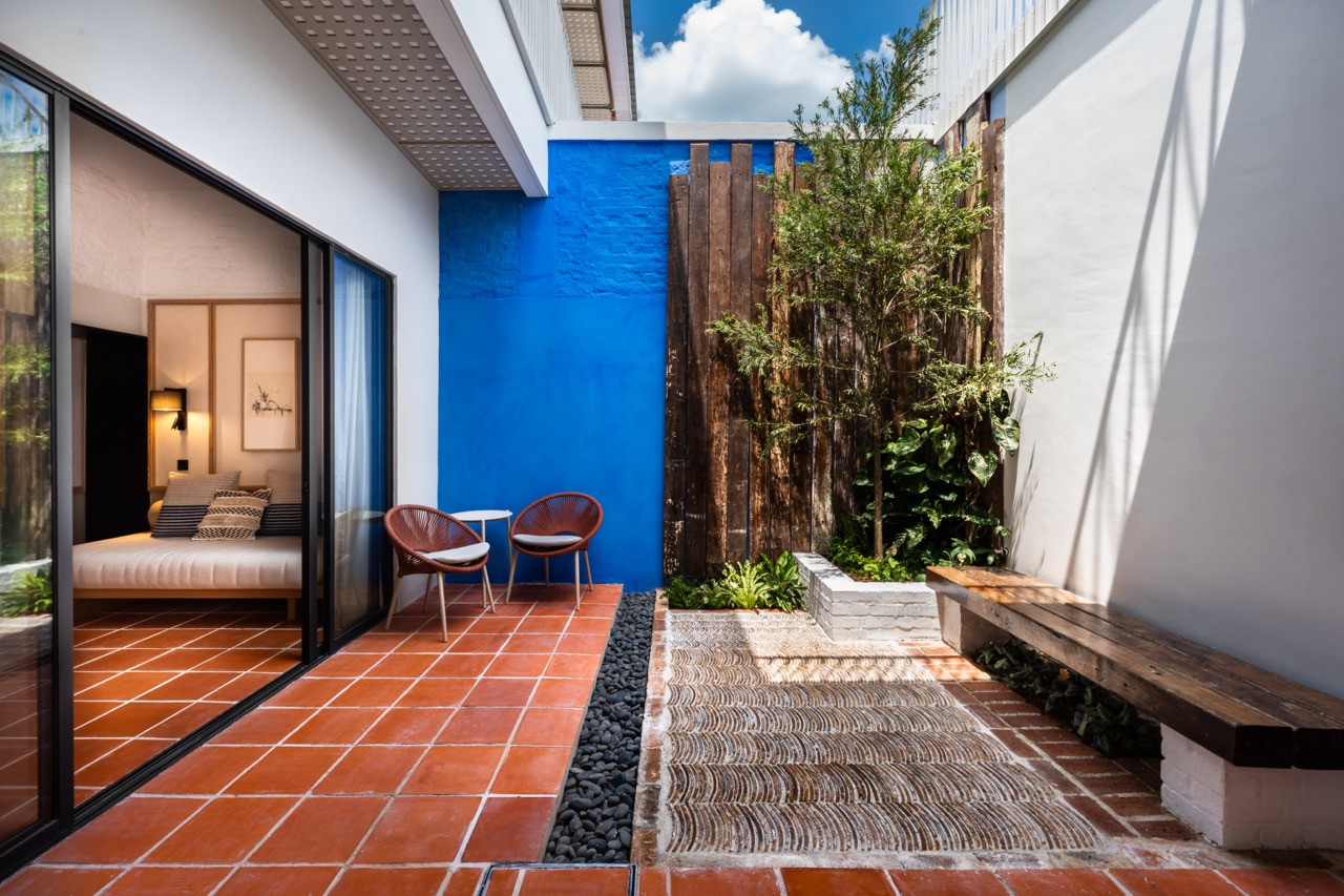 Each Garden Suite includes a private walled garden with a blue accent wall that references the indigo of the main mansion