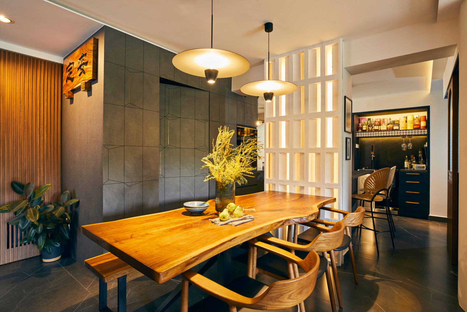 a wall of ventilation blocks serves as a partition between the dining and bar areas in this Chai Chee apartment