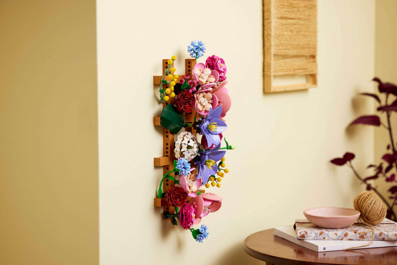 Lego’s Flower Wall is mounted vertically. The medium nougat Technic brick lattice holds 25 individual flower heads, each attached via bar connections that allow the arrangement to be reconfigured without tools