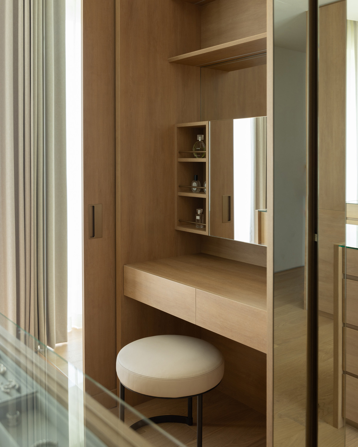 Mirrored surfaces in the walk-in wardrobe enhance its sense of spaciousness