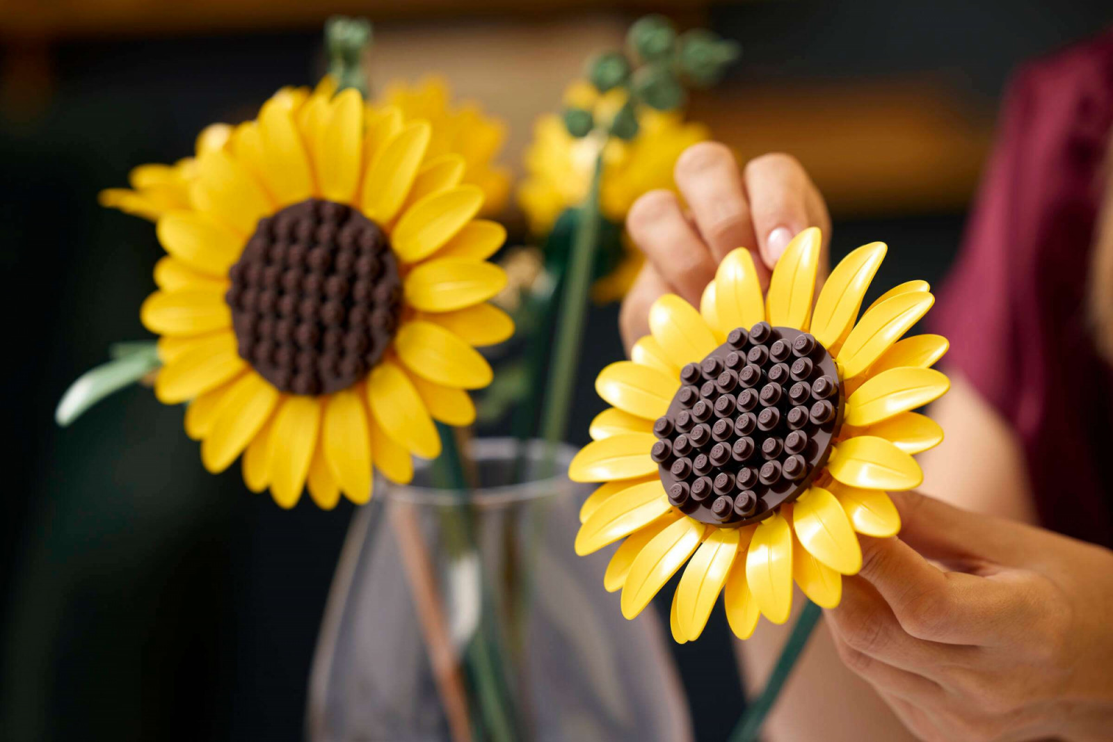 The disc centre uses a 6x6 dark brown round plate as its base, with the ray petals — each made from a 2x6 yellow leaf piece — clipped around the perimeter