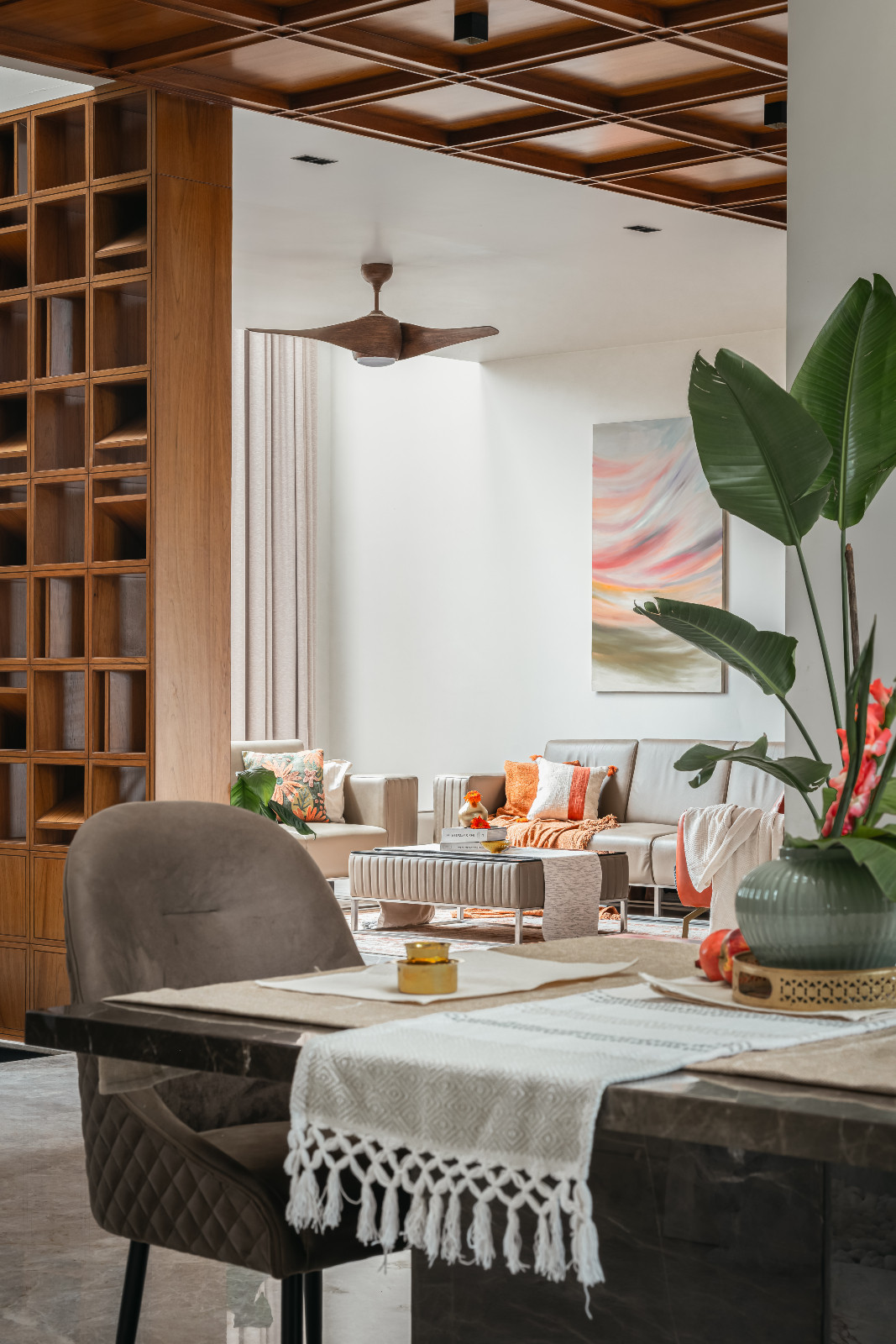 The dining room with a glimpse of the living room area in a family home in Bengaluru, India designed by Architecture + Swath