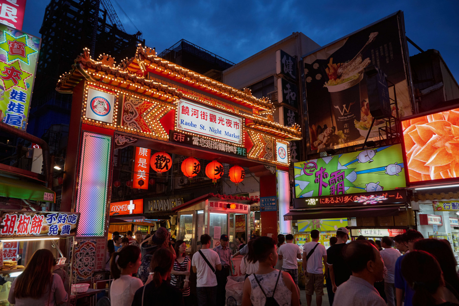RAOHE NIHT MARKET, TAIPEI, TAIWAN - 2018/07/03: Tourists and locals walk around Raohe night market in the early evening. The market is one of the most popular in Taipei, with a wide variety of street food, stalls and games available.Each end of the market, which occupies a city street, features a traditional Chinese gate with the name of the market on it. (Photo by Craig Ferguson/LightRocket via Getty Images)