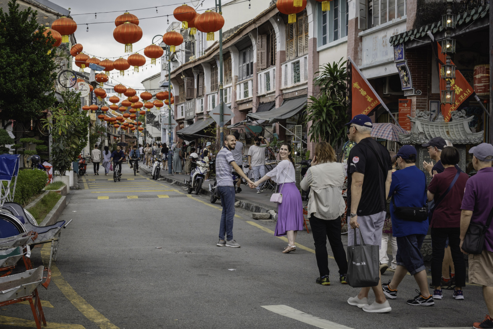 PENANG, MALAYSIA - 2024/01/16: A couple seen walking along the street at George Town City, Penang Island. George Town is the colorful, multicultural capital of the Malaysian island of Penang. The colonial streets of George Town are a center for culture, street art, and the country's best street food. (Photo by Nathalie Jamois/SOPA Images/LightRocket via Getty Images)