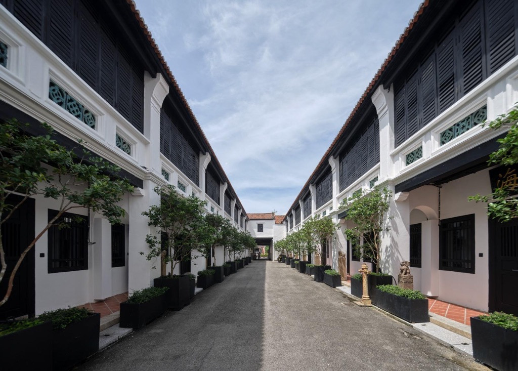 The two rows of restored shophouses facing each other across the Khoo Kongsi compound lane, a spatial arrangement that mirrors Chan's childhood memory of a multigenerational community where families lived across from one another