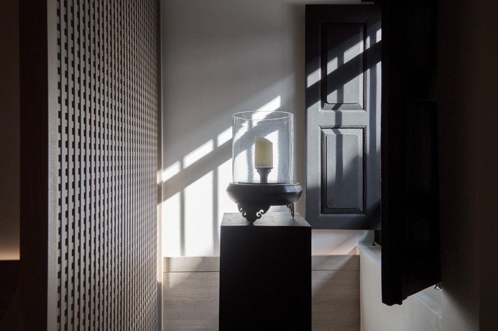 Light through original black-painted shutters cuts across the interior, the contrast between darkness and sharp illumination that runs as a constant thread through Chan's design
