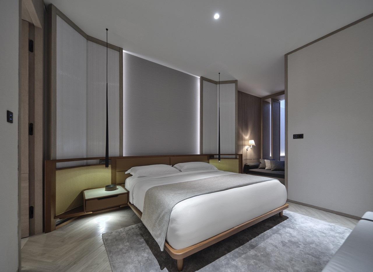 A guest suite at Soori Penang, where warm timber, pendant lighting and a restrained palette replace the Peranakan iconography typical of George Town's heritage hotels