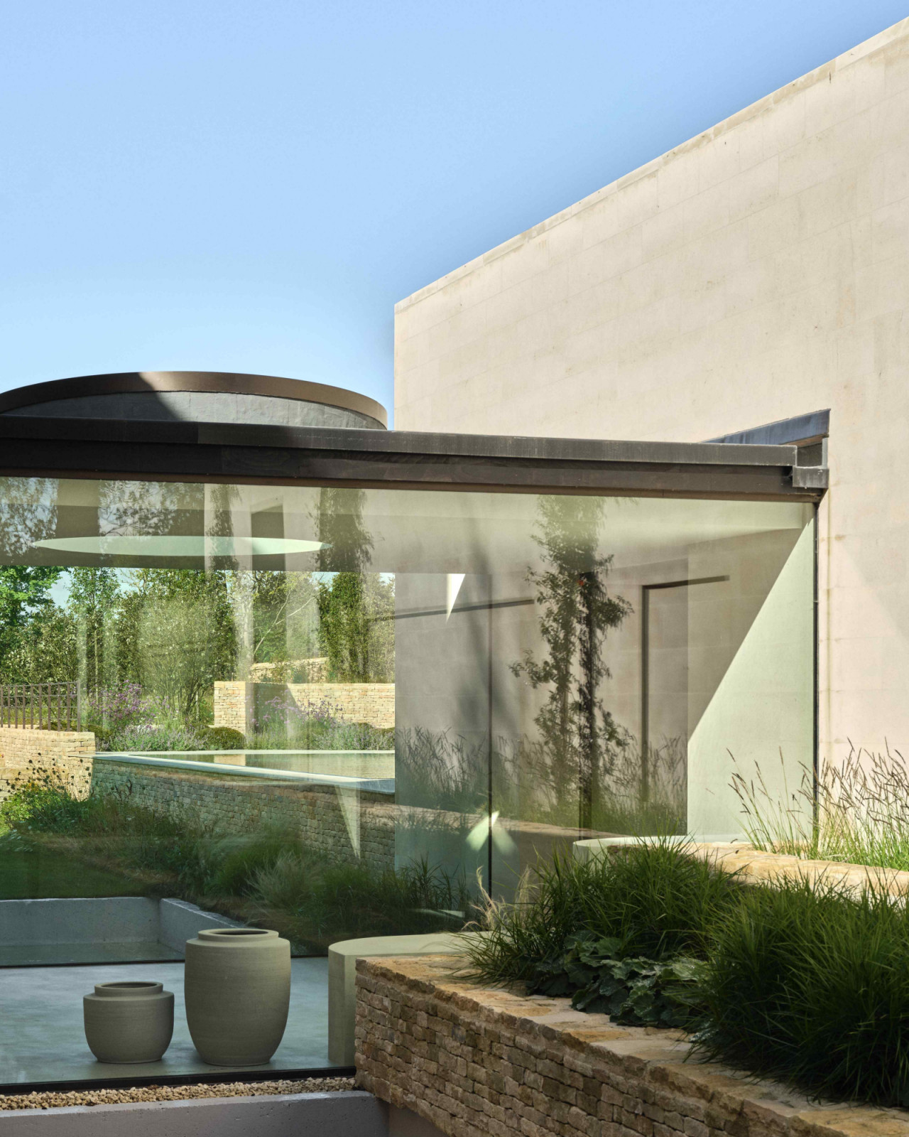 The glass-encased corridor bridges the original stone house with the new, contemporary wing extension