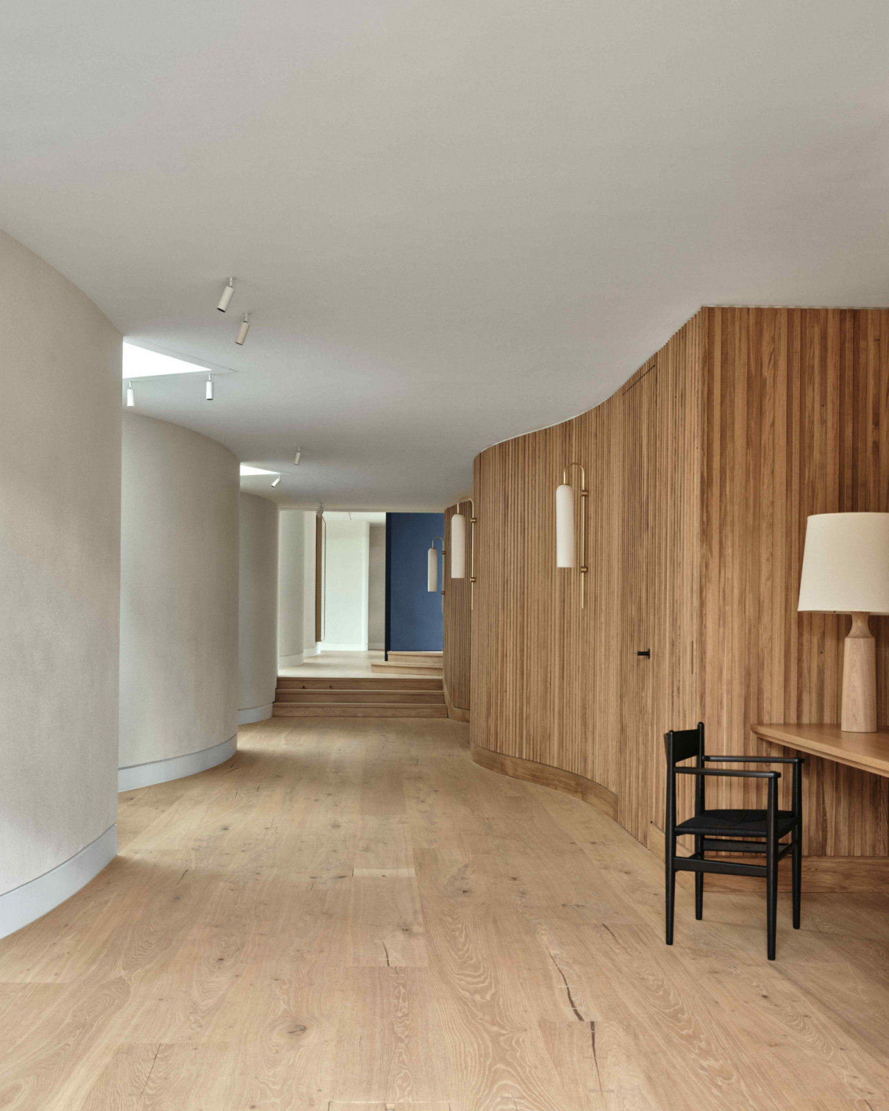 Undulating textured plaster walls and vertical timber panelling