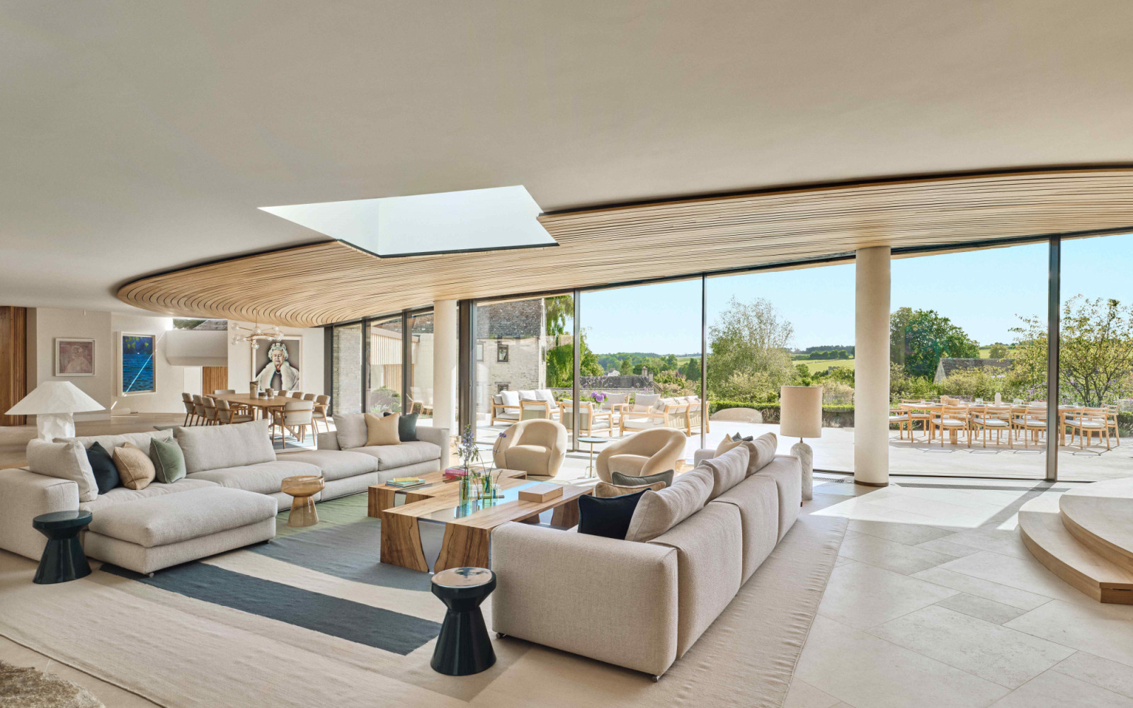The grand drawing room with expansive floor-to-ceiling glazing that frames views of the landscape