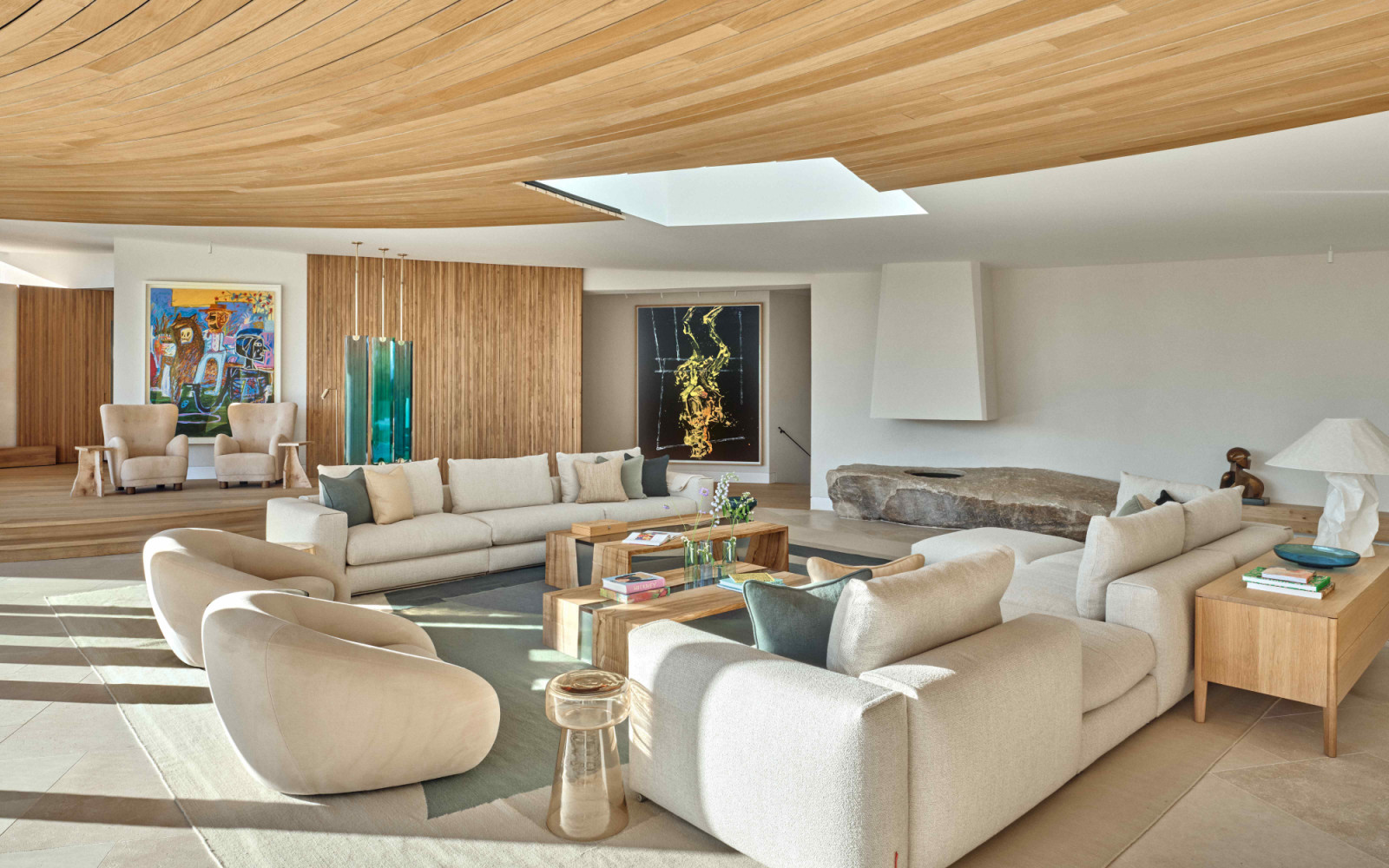 The living area with a raised podium sitting area and a hidden bar concealed within the negative space of the curved concrete wall